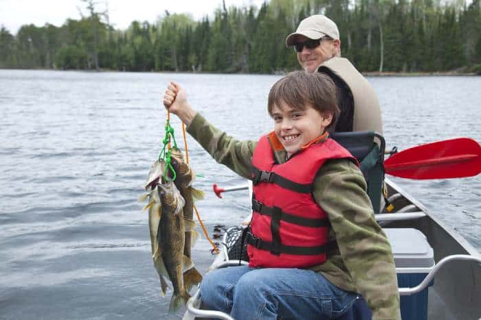 Man and boy fishing on lake