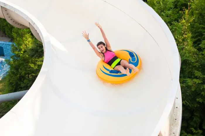 a woman going down a tall water slide in a tube