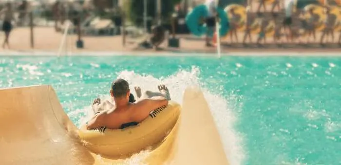 man going down a water slide in an innertube