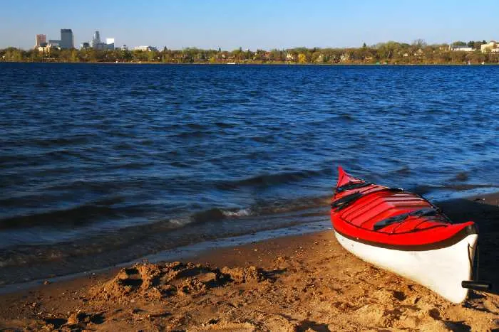 Red kayak on lakeshore.