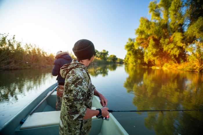 two men fishing on a river