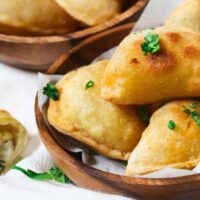 Cheesy perogies in wooden bowl.