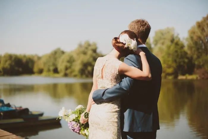 Bride and groom next to lake