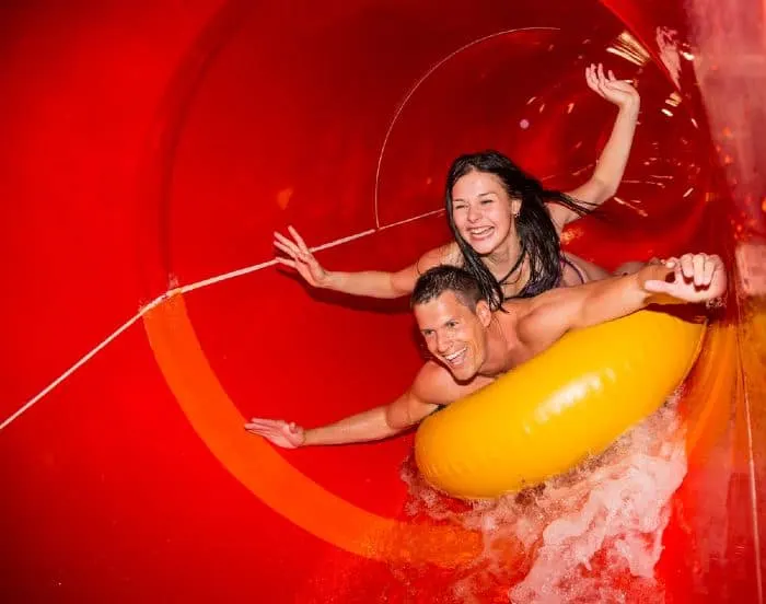 A couple having fun sliding down a water slide