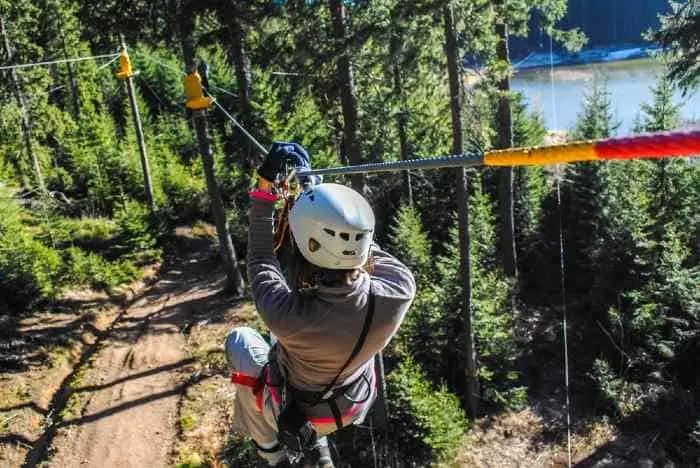 A Woman zip-lining through the forest.