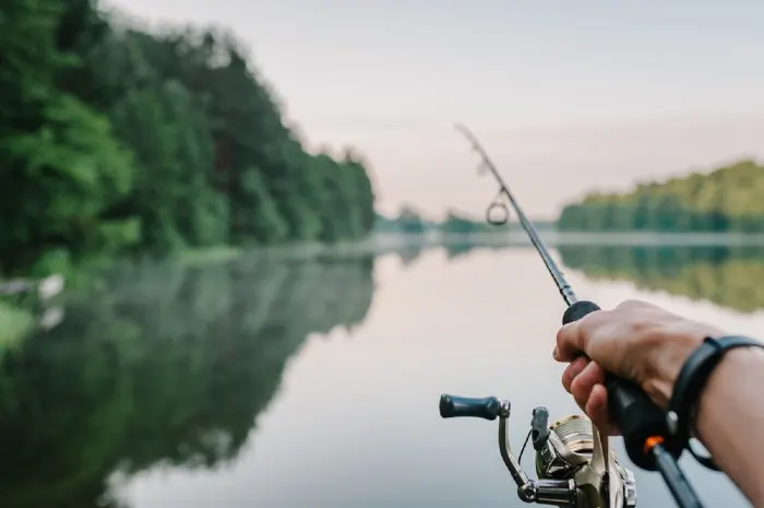 Fisherman with rod, spinning reel