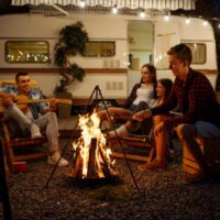 Campers at campsite roasting marshmallow over a fire