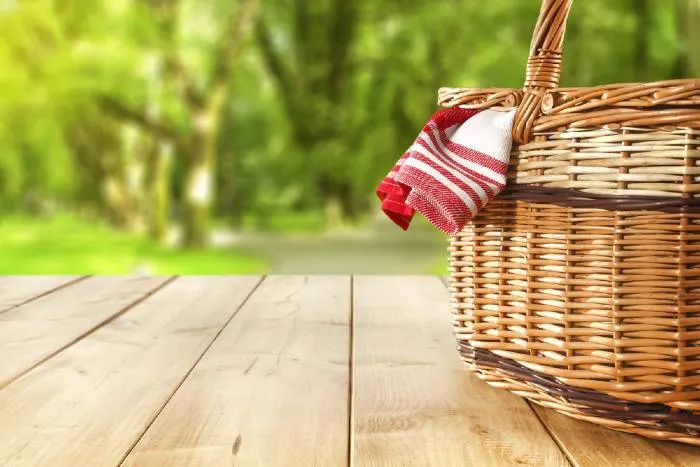 A red napkin picnic basket and table place
