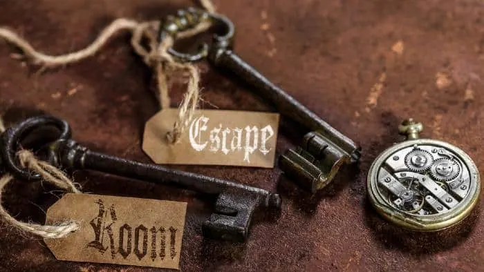 two old keys on a rusty metal table with labels : escape room
