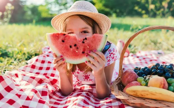 Young girl eating watermelon on a picnic