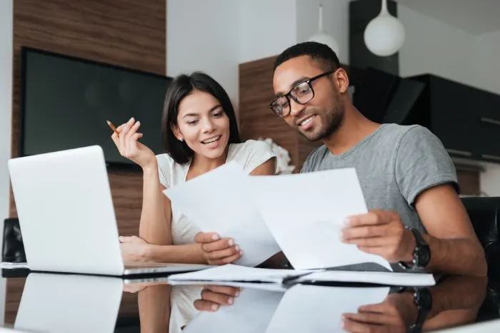 A young couple using a laptop and analyzing their finances