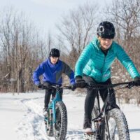 Couple riding fat tire bikes in snow