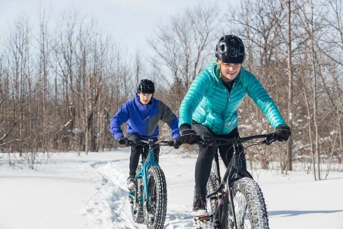 A couple riding fat bikes in the snow; one of the fun things to do in Albert Lea in winter
