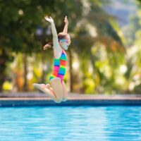 Young girl jumping into pool