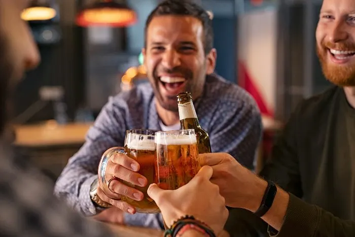 Friends toasting with beer at one of the best things to do in Big Lake
