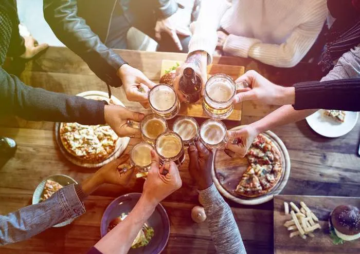 Group of people celebrates a party with food and beer
