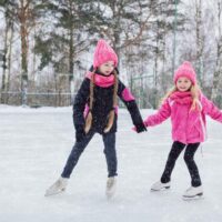 Two girls outdoor ice skating