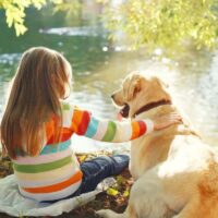 Young girl at lake with dog