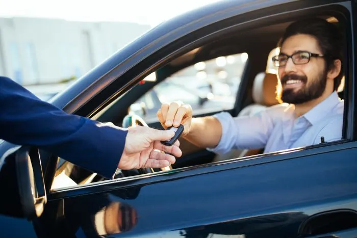 Young and handsome businessman buying a used car