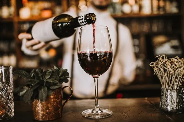 Bartender pouring red wine