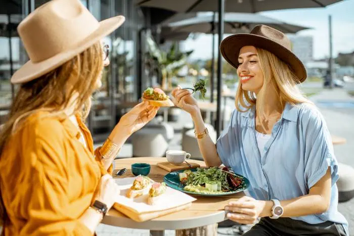 friends eating healthy food while sitting together on a restaurant terrace