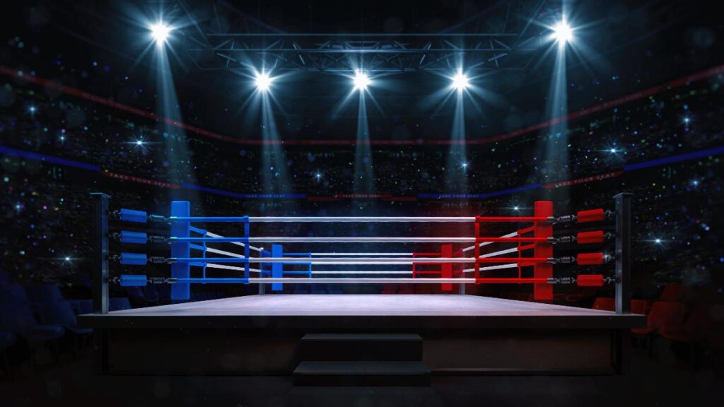 Boxing fight ring close-up. Interior view of sport arena with fans and shining spotlights. 