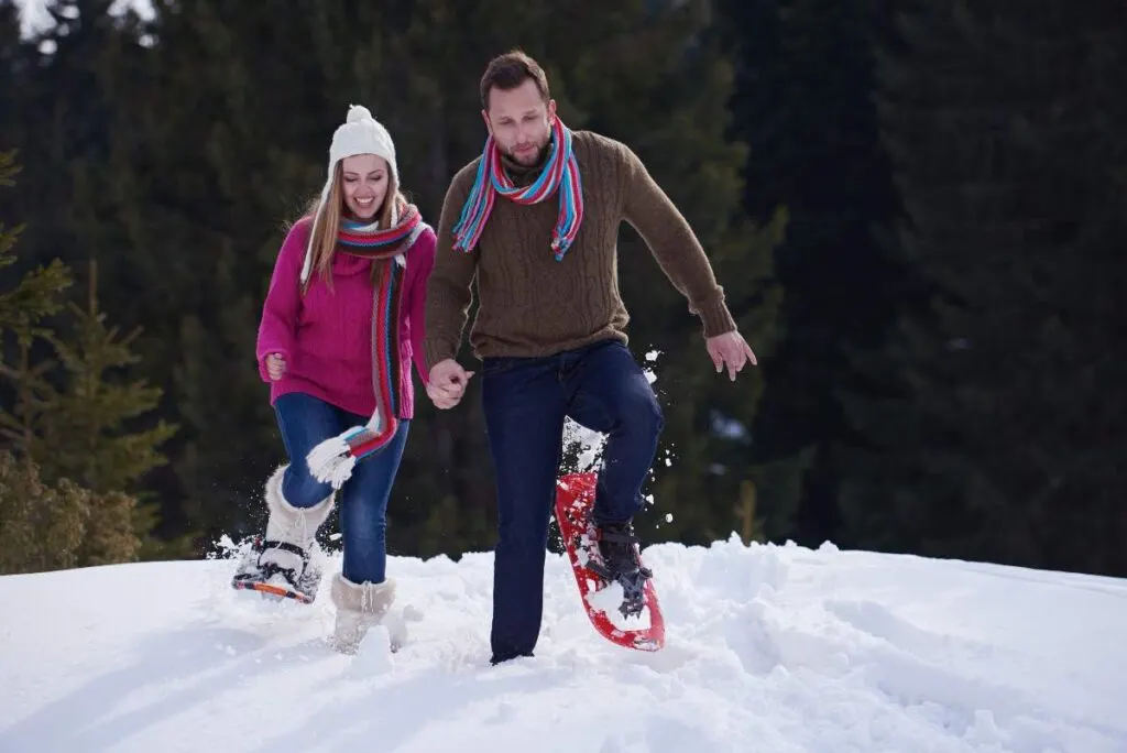 couple having fun and walking in snow shoes