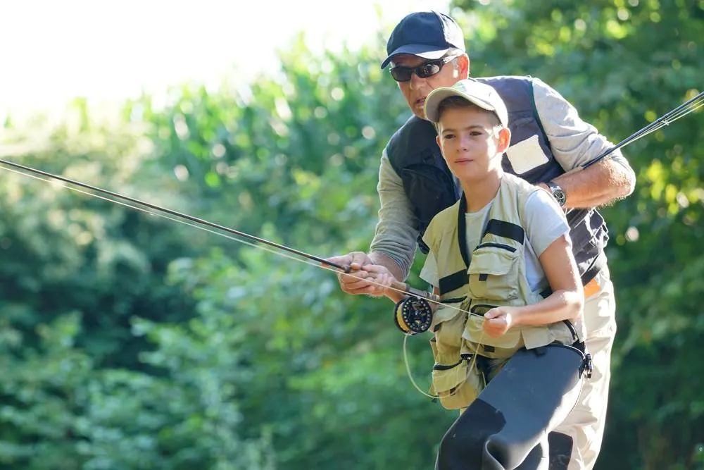 Father teaching sone how to fly fish