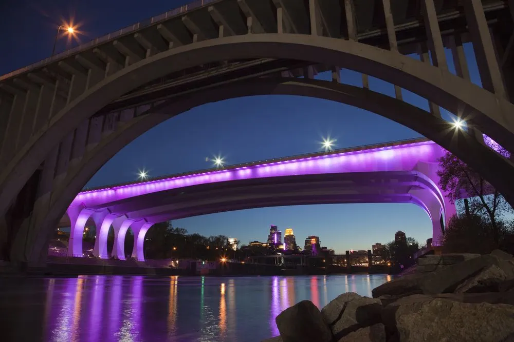 MINNEAPOLIS, MINNESOTA, USA - APRIL 22, 2016: The I-35W bridge over the Mississippi River in Minneapolis is lit with purple lights in honor of the passing of music legend Prince.