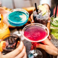 Friends toasting with drinks at happy hour