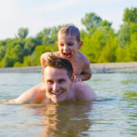 Father and son playing in water