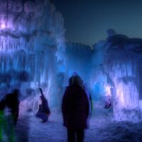 Silhouettes in front of purple and blue ice castles.