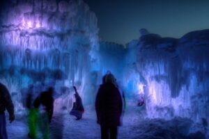 Silhouettes in front of purple and blue ice castles.
