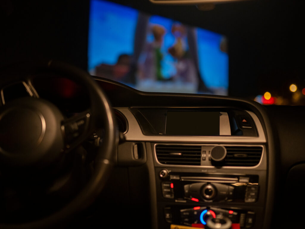 A drive in theater seen from the inside of the car.