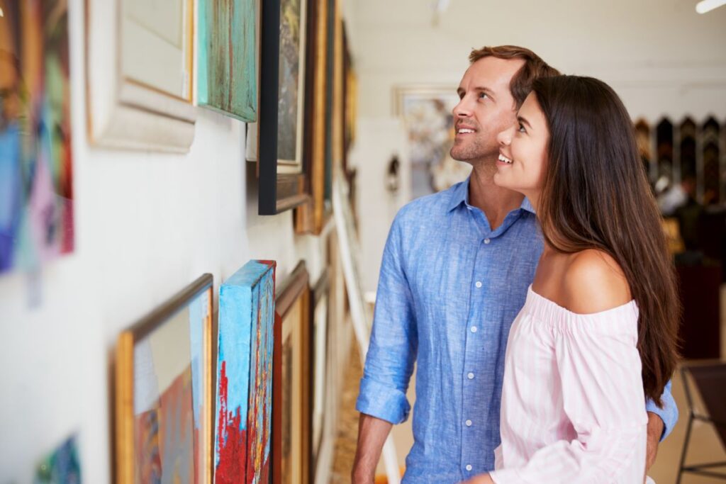 A couple looking at paintings in an art gallery.