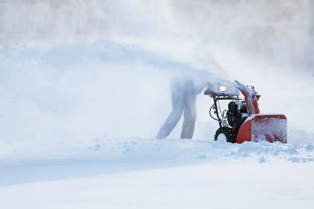 a red snow blower in the snow - maybe one of the best snow blowers!