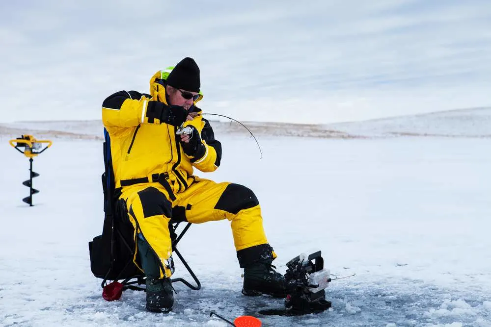 Ice fisherman fighting a fish.