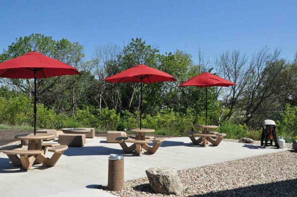Tables and chair with red umbrellas poolside