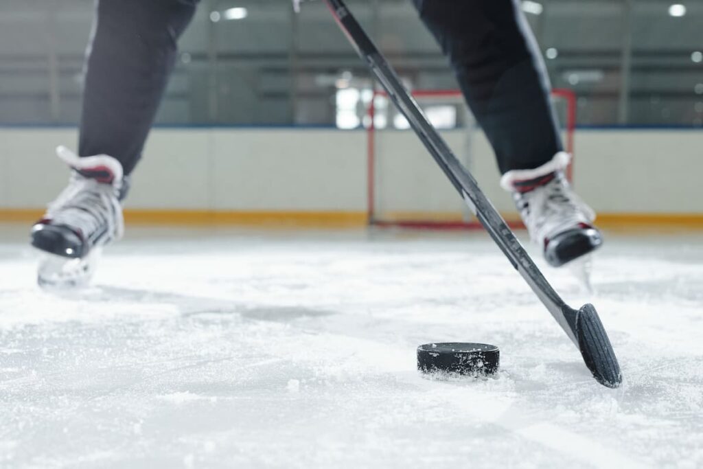 View of the legs of a hockey player while on the ice, a goal in the background. Best hockey sauce kits.