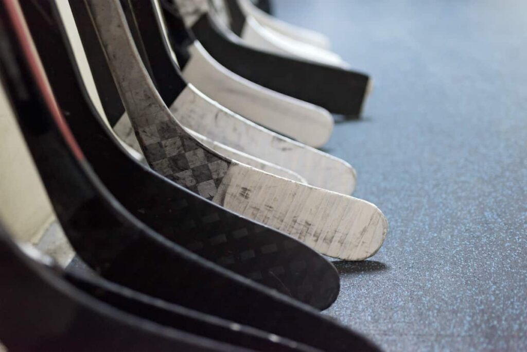 Closeup of a row of hockey sticks.
