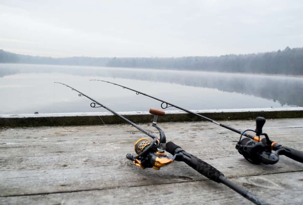 A pair of fishing rod on a dock on a cold, foggy day.