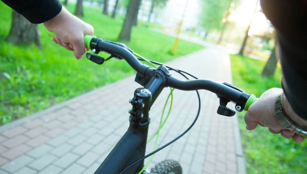 Person riding a bike in a city park setting.