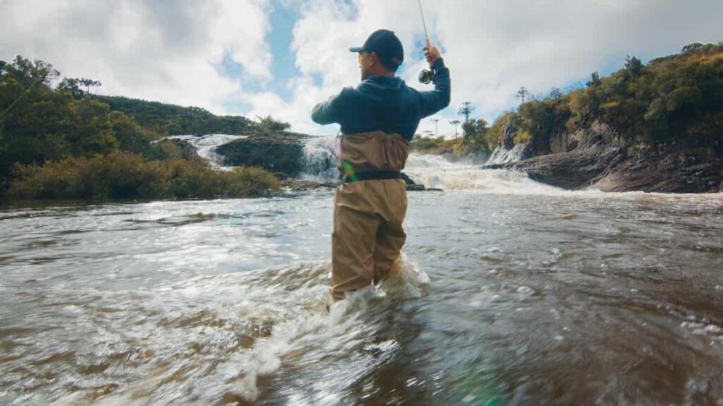 A fisherman wearing waders fly fishing. Best trout fishing gear.
