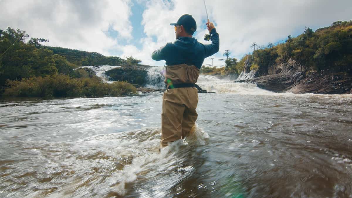 Fisherman in waders fly fishing.