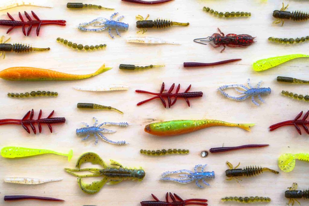 Assorted plastic fishing lures laid out on a table.