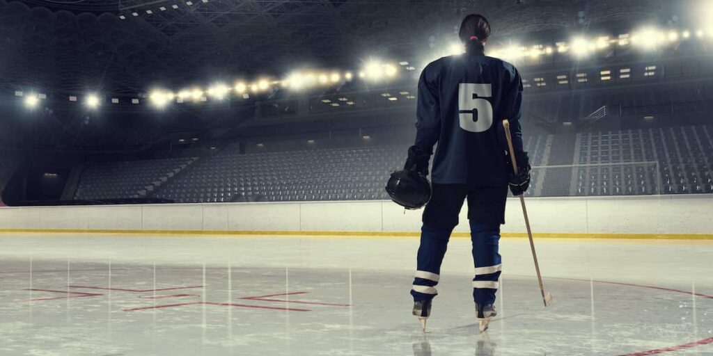 A woman ice hockey player standing on the ice.