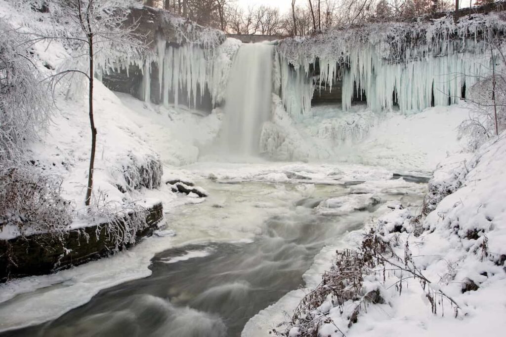 A view of Minnehaha Falls mostly frozen in the winter.